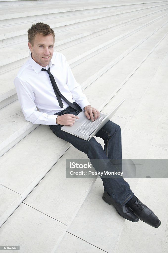 Casual Uomo d'affari in ufficio digitando sul computer portatile si - Foto stock royalty-free di Abbigliamento casual