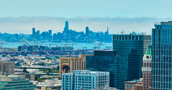 Image of Oakland aerial over city skyscrapers with zoomed in view of distant San Francisco downtown