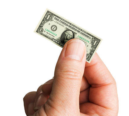 Subject: A hand holding a shrinking U.S. dollar note isolated on a white background.