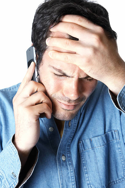 istock frustrated man listening on phone against white background 174673159