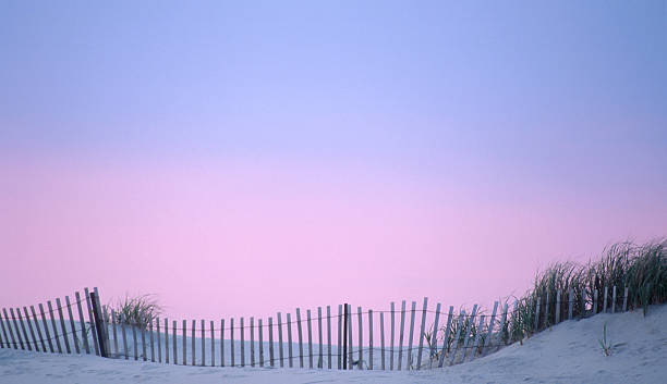 duna parete sulla spiaggia con cielo al tramonto - contea di cape may foto e immagini stock