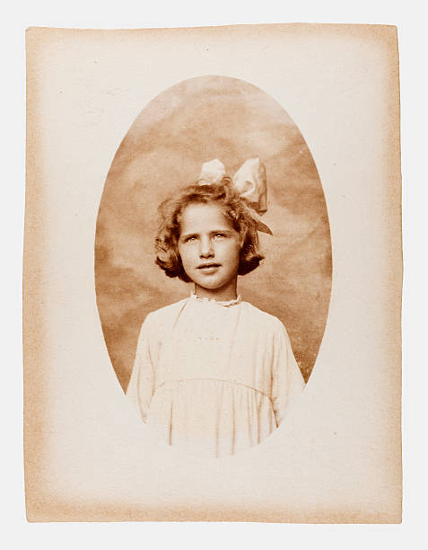 Vintage Portrait of Girl With Ribbon in her Hair Vintage sepia toned black and white portrait of a young girl with ribbon in her hair. Some dust and scratches which convey age of original image. edwardian style photos stock pictures, royalty-free photos & images