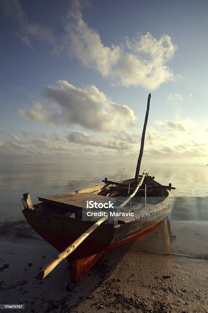 fishing boat "old fishing boat resting on the beach of Zanzibar, at sunrise." Art Stock Photo