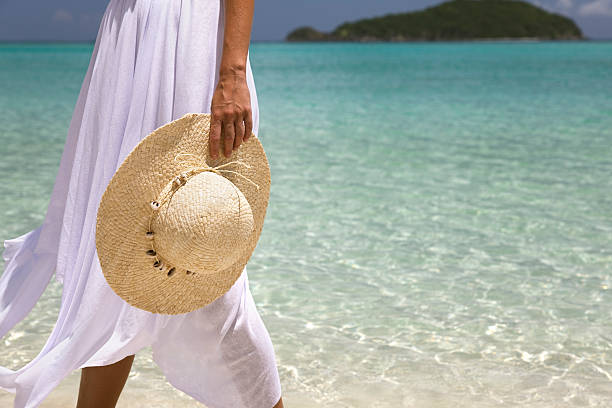 istock woman in dress walking with hat 174676108
