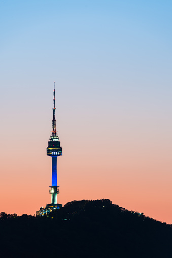 The iconic spire of Namsan Tower on the mountain at sunset overlooking central Seoul, South Korea’s vibrant capital city.