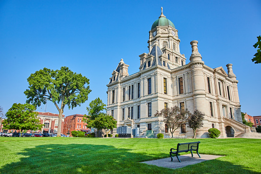 Image of Whitley County Courthouse with bench on slab in green lawn