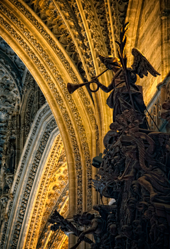 angel scuplture with a music horn in one of the altars of sevilla cathedral (la giralda), spain