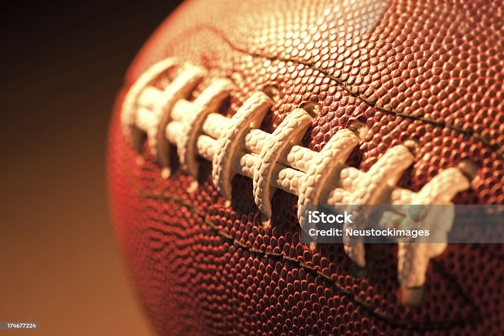 Primo piano del football americano su sfondo scuro - Foto stock royalty-free di Attività ricreativa