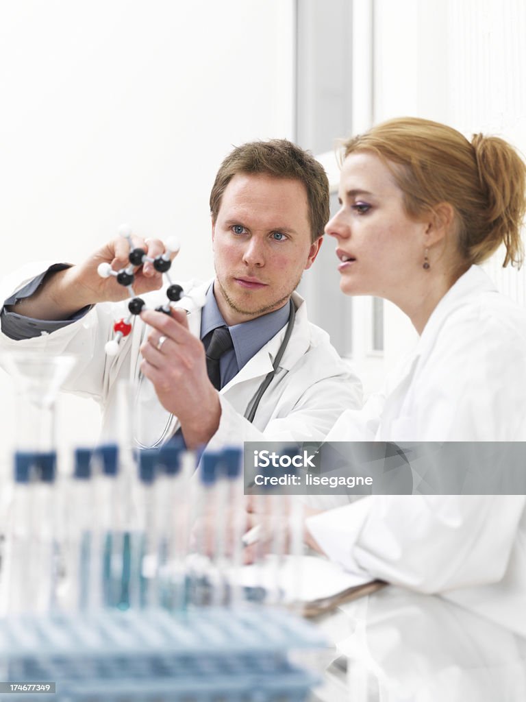 Investigadora y médico examinar una estructura molecular - Foto de stock de 25-29 años libre de derechos