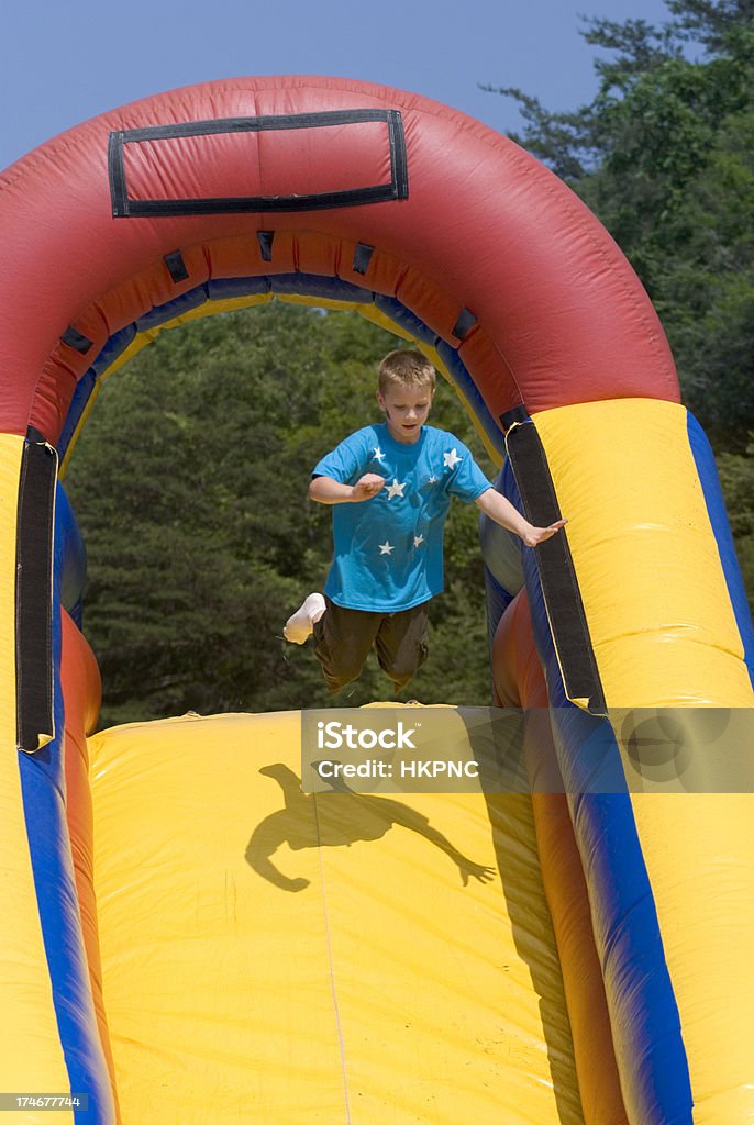 Junge springen auf aufblasbare Wasserrutsche ein - Lizenzfrei Aktiver Lebensstil Stock-Foto