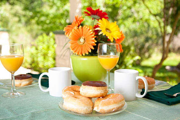 terraço mesa com prato de novas donuts e sumo de laranja - texas tea imagens e fotografias de stock