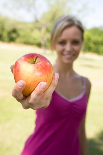 istock Young Woman Holding Out an Fresh Apple 174678133