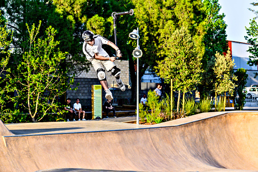 Igualada, Barcelona; June 28, 2023: Young man practicing Scootering (Freestyle Scootering) in the new SkatePark of the central park of Igualada, Barcelona