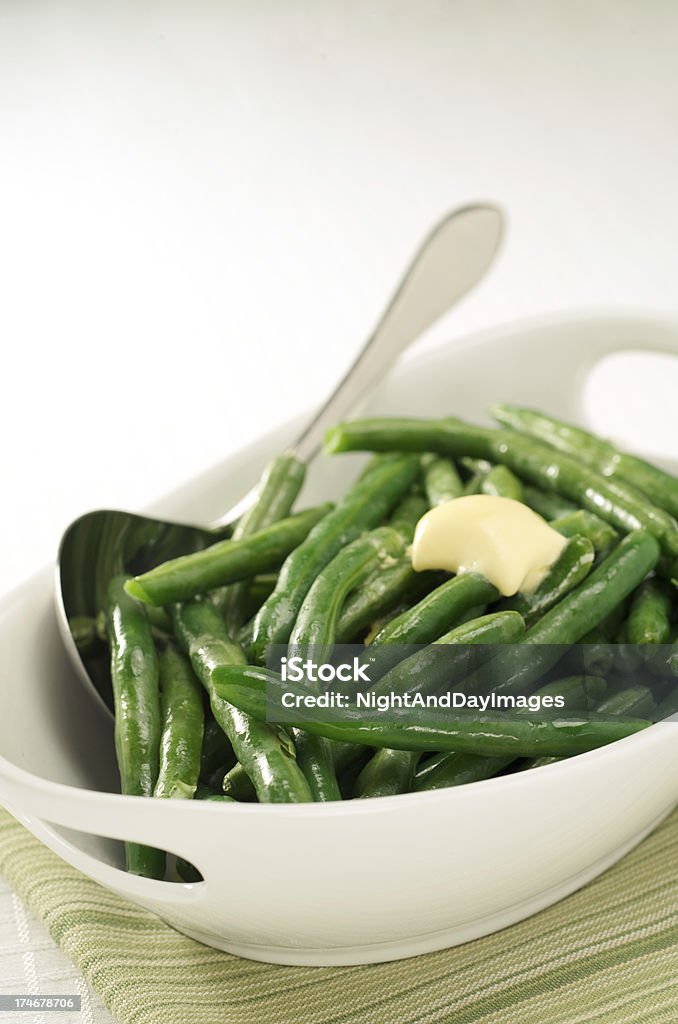 Healthy Steamed Green Beans with Butter, White Bowl Freshly steamed green beans with melting butter. Bean Stock Photo