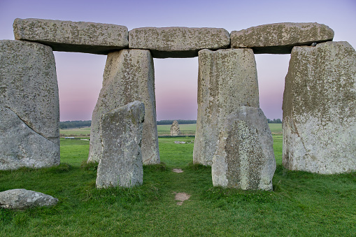 View from the center of Stonehenge looking out through the doorway at the heel stone at sunset