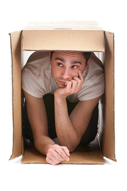 istock Man inside of cardboard box against white background 174678889
