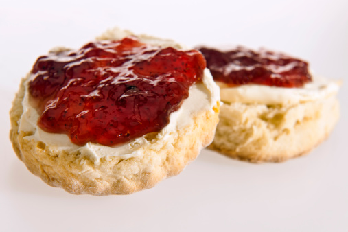 scones with jam and cream against a white background