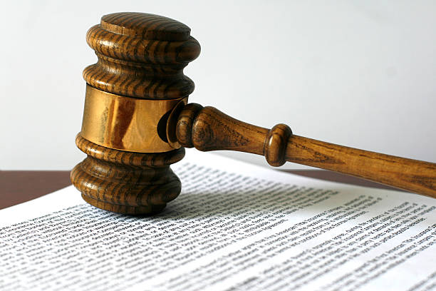 Gavel on document. "Gavel on copy of escrow agreement, soft shadow. White background, soft shadow. Gavel has seen much use. Please see more gavel photos:" legal document stock pictures, royalty-free photos & images