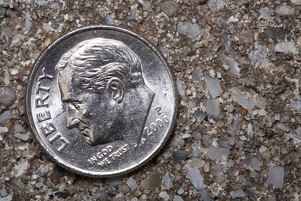 istock Close-up of an old worn dime on the sidewalk 174680460