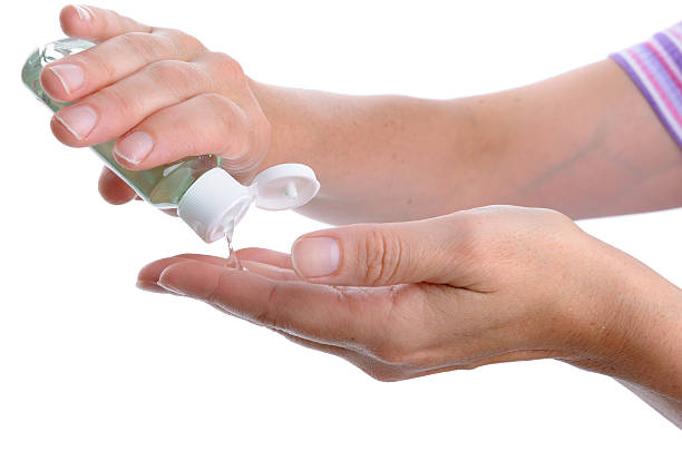 Woman Washing Hands with Alcohol Sanitizer stock photo