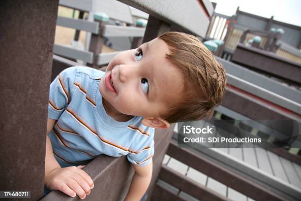 Happy Boy Looking Up At Playground Stock Photo - Download Image Now - 12-17 Months, Below, Brown Hair
