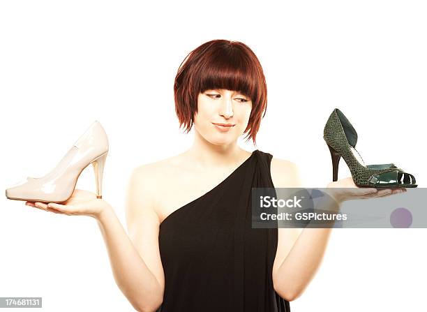 Joven Mujer Tratando De Elegir Entre Dos Pares De Zapatos Foto de stock y más banco de imágenes de 20 a 29 años