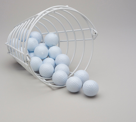 Practice Bucket of White Golf balls on gray background.