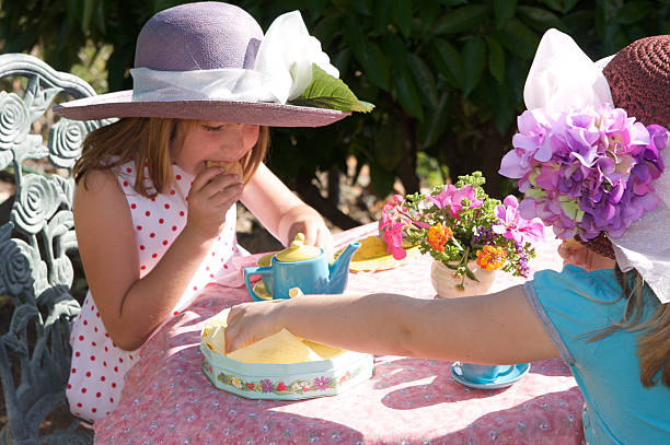 tea party al aire libre-niñas con adornos rígidos - tea party dressing up little girls hat fotografías e imágenes de stock