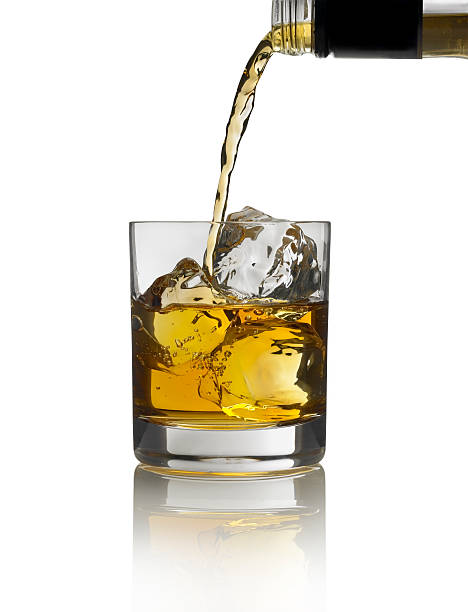 złota alkohol wlewając do szkła z lód na białym tle - whisky glass ice cube alcohol zdjęcia i obrazy z banku zdjęć