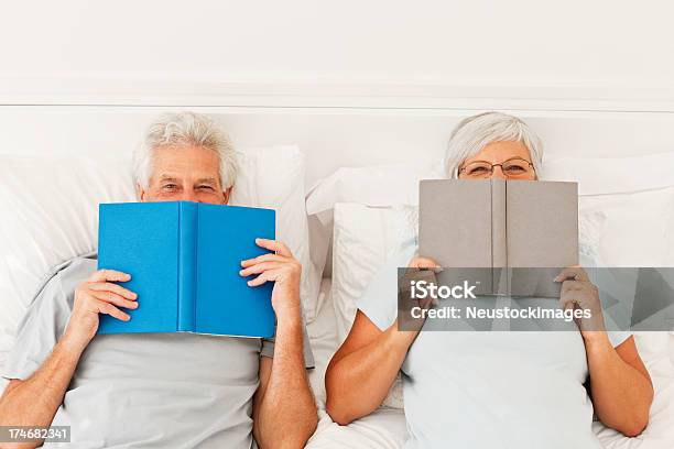 Jubilados Senior Pareja En La Cama Con Libros Foto de stock y más banco de imágenes de Libro - Libro, Cara oculta, Mujeres