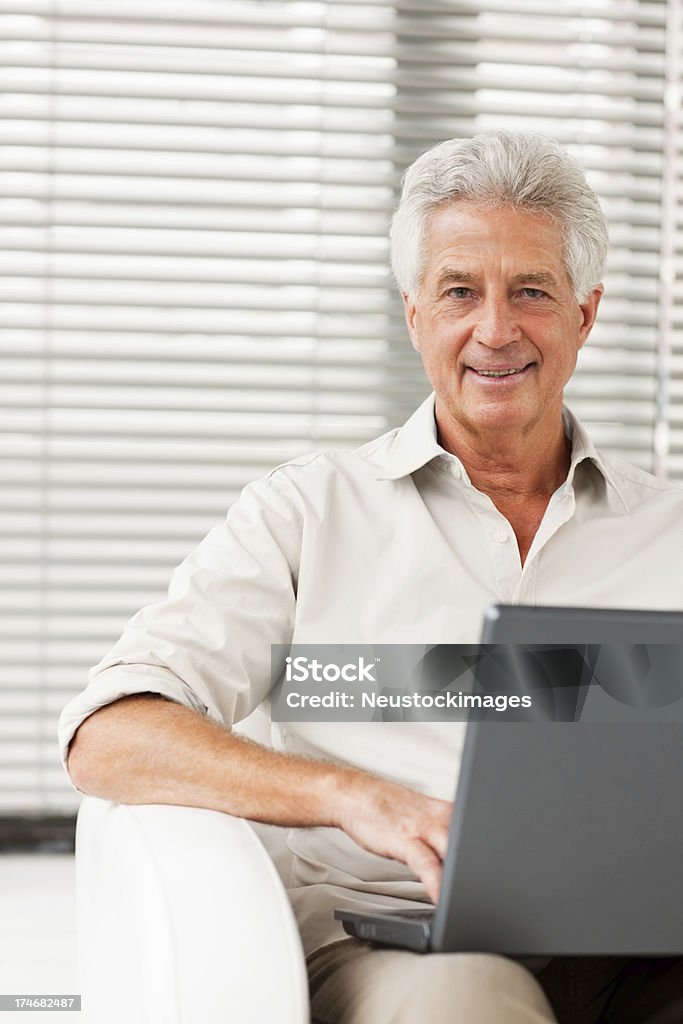 Feliz sênior homem sentado com laptop - Foto de stock de 60 Anos royalty-free