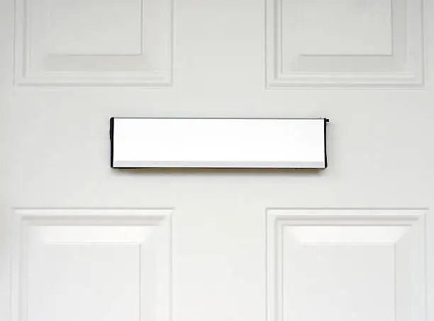 Close up of a mail slot in a residential front door.  See also