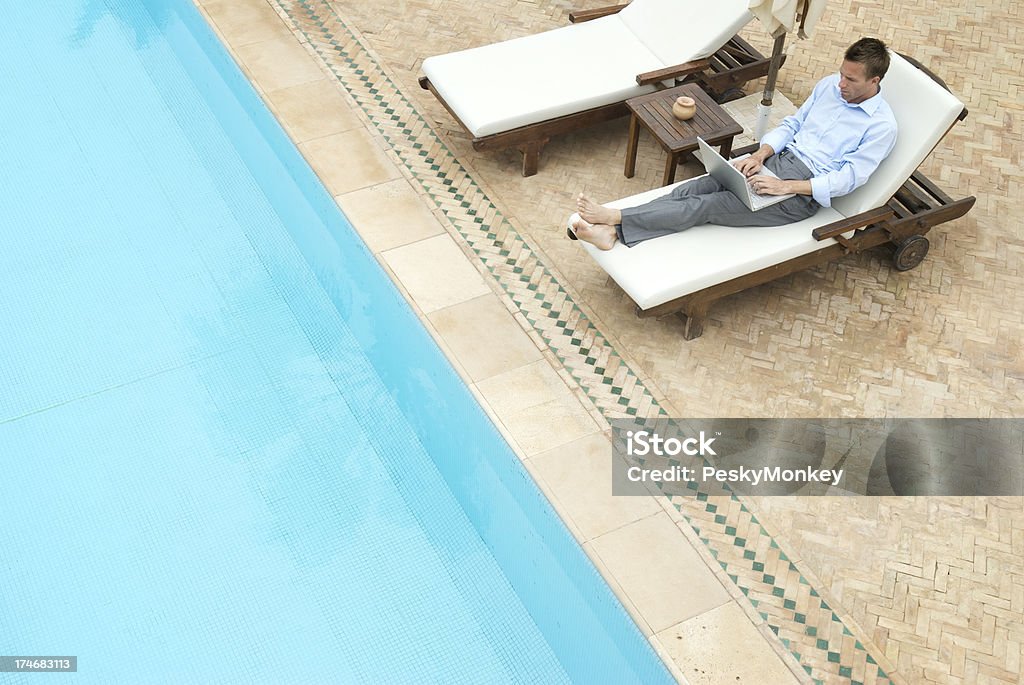 Empresário relaxado trabalhando no Laptop sentado ao lado da piscina - Royalty-free Piscina Foto de stock