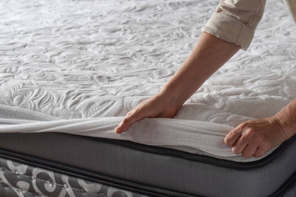 istock Woman putting protective mattress pad on a new mattress 1746831254