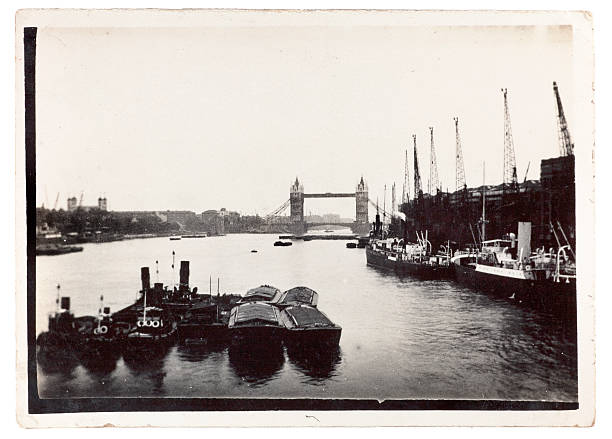 Tower Bridge London 1920 "Vintage black and white photograph of the River Thames, London, with Tower Bridge and the Tower of London visible to the left. Taken from London Bridge looking east.  Some dust and scratches which convey age of original image, taken in the 1920's." thames river photos stock pictures, royalty-free photos & images