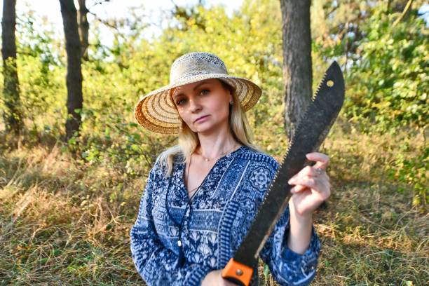 Beautiful sexy woman with a machete in the forest.