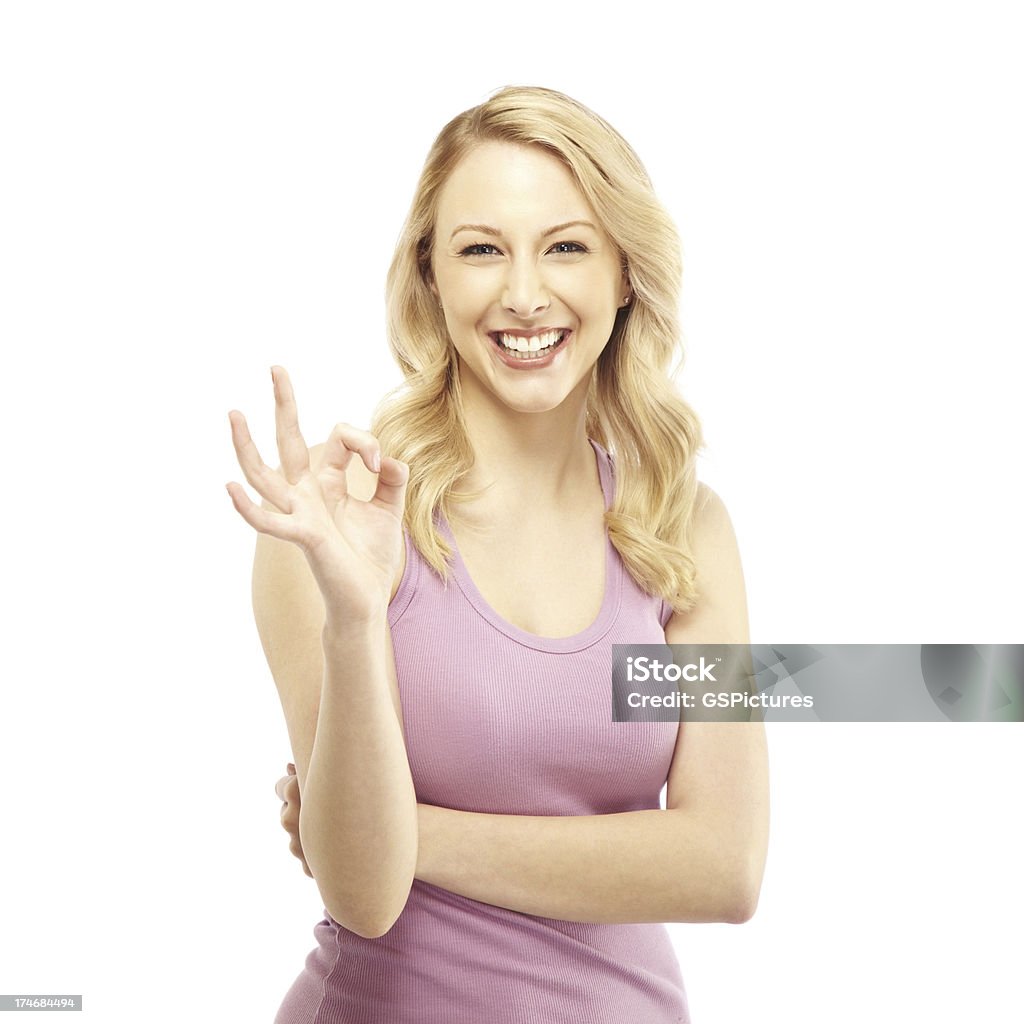 Attractive Blond Woman Making 'OK' Hand Gesture Smiling young female showing ok gesture 20-24 Years Stock Photo