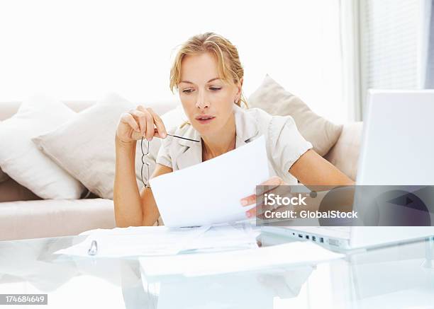 Foto de Meados Mulher Adulta Passando Seus Documentos e mais fotos de stock de Concentração - Concentração, Laptop, Só Uma Mulher