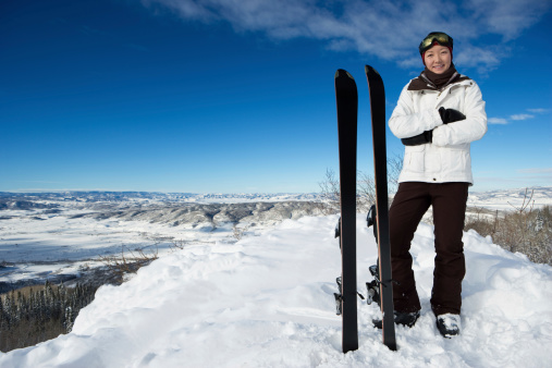 Beautiful outdoor portrait of young female on the top of a ski mountain.