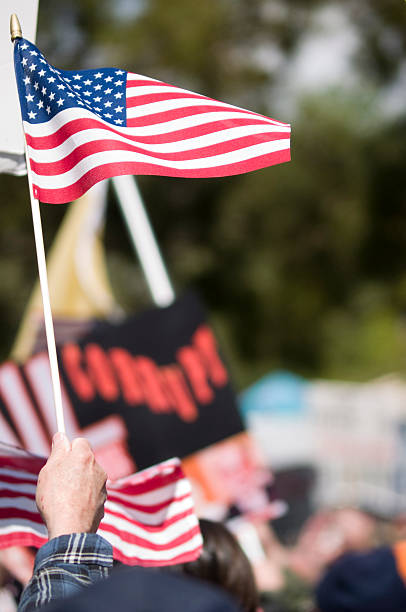 istock man waving an American flag at a protest rally 174685280