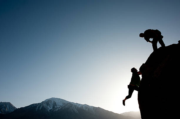 istock Silhouette of climbers on a rock 174685406