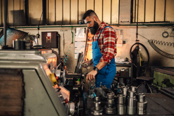 istock A young machinist operating a factory machine and holding a cloth. 1746855668