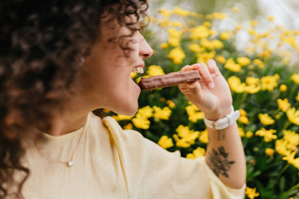 istock woman in profile biting chocolate bar on spring day 1746858978
