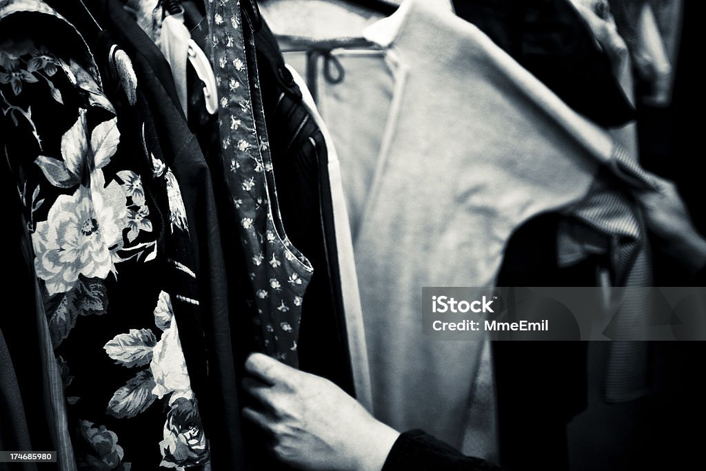 Shopping Shopping. Hands touching clothes. Focus on clothes at left. Noise added. Black And White Stock Photo