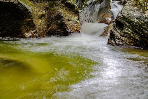 Cascading water over bright green moss-covered boulders in Tennessee