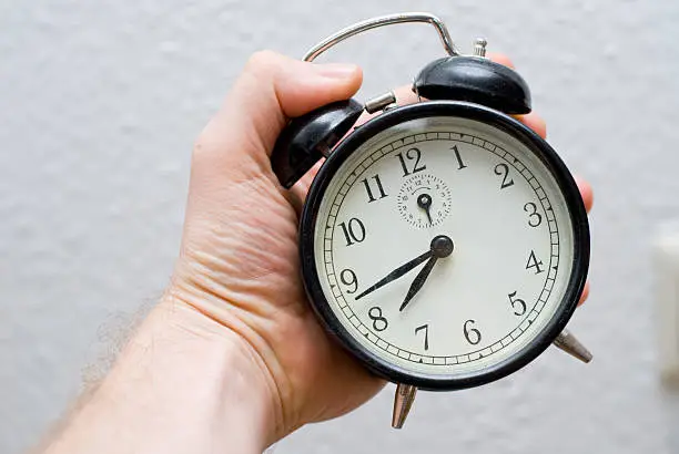 alarm clock in human hand