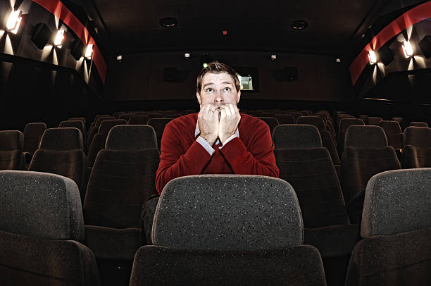 istock Scared Man Sitting in Movie Theatre Alone 174686637