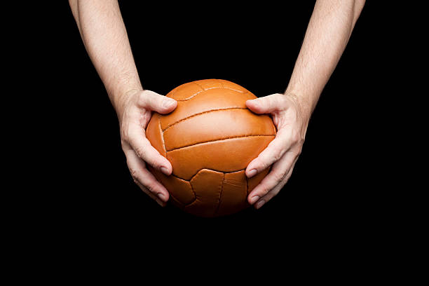 アンティークのサッカーボールを手の選手 - soccer ball old leather soccer ストックフォトと画像