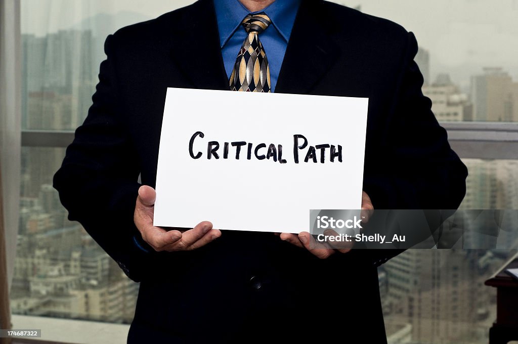 Business Sign Critical Path a Businessman holding a Critical Path sign during a presentation. Bringing Home The Bacon Stock Photo