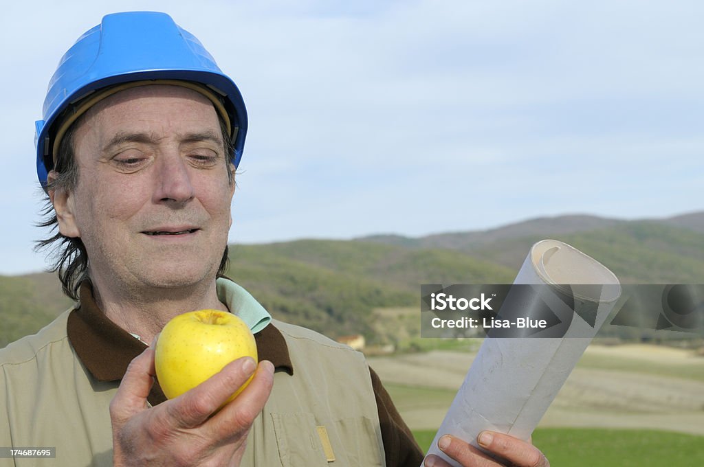 Inżynier eating an apple - Zbiór zdjęć royalty-free (45-50 lat)